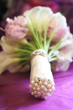 the bride's bouquet is wrapped in pearls