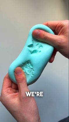 a hand holding a blue soap bar with the words we're here written on it