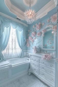 a bathroom decorated in blue and white with pink flowers on the wall next to the tub