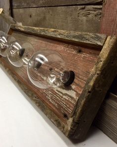 an old wine glass rack with three wine glasses on it