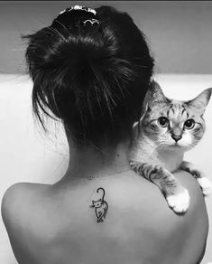 a woman with a cat on her back shoulder