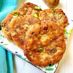 three fritters are on a plate with a blue towel