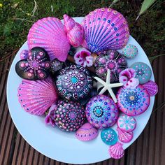 there is a plate full of colorful seashells and starfish on the table