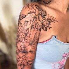 a woman with a flower tattoo on her arm and shoulder is looking at the camera