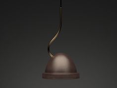 a light that is hanging from a ceiling in a dark room with a black wall behind it