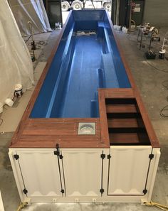 an empty swimming pool in the middle of a room with other equipment on the floor