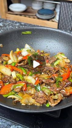 stir fry with beef and vegetables in a wok on the stove top, ready to be cooked