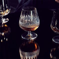 three wine glasses sitting on top of a table