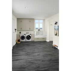 an empty laundry room with washer and dryer in the corner on the far wall