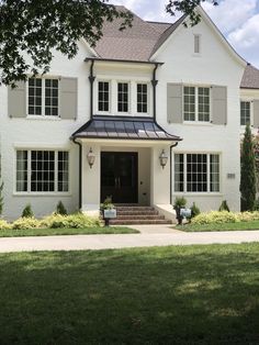 a large white house with black trim and windows