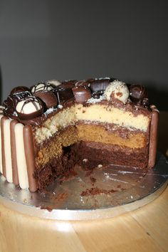 a chocolate cake with white frosting and chocolate candies on it's side