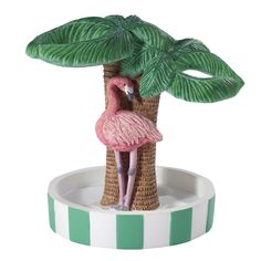 a pink flamingo standing on top of a palm tree