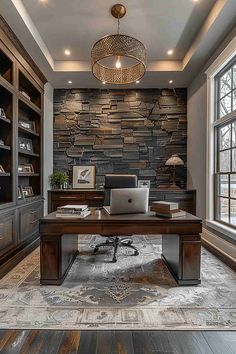 a home office with stone wall and wood flooring, built in shelving units