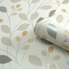 a wall paper with leaves on it and a roll of tape next to it that is laying on the ground