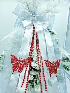 a white bow with red and white beads hanging from it's centerpieces