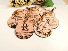 six wooden tags with names on them sitting next to flowers