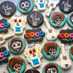 decorated cookies are arranged in the shape of guitars and skull heads on a wooden table