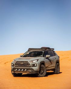 a grey suv is parked in the desert