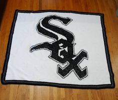 a chicago white sox baseball team rug on a wooden floor with a black and white logo