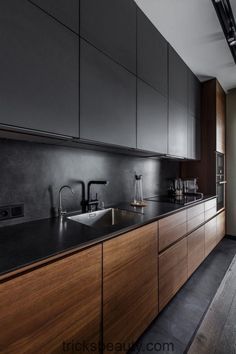 a kitchen with black counter tops and wooden cabinets