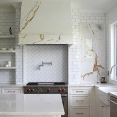 a kitchen with marble counter tops and white tile backsplashes on the walls