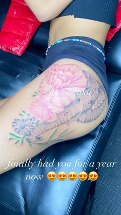 a woman's leg with tattoos on it and flowers in the bottom half of her thigh