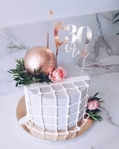 a white cake with pink flowers and a gold topper that says 30th birthday on it