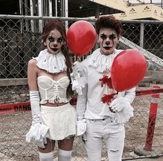 two people dressed up as zombies holding red balloons