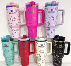 the hello kitty travel mugs are lined up in different colors and designs on them