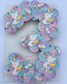 the letter e is made out of cupcakes and icing, with an unicorn on it