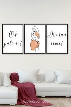 three framed art prints on the wall in a living room with white couches and pillows