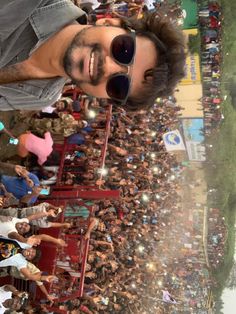 a man with sunglasses standing in front of a crowd