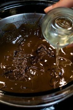 someone pouring melted chocolate into a bowl