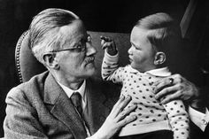 an older man holding a small child in his lap and looking at the baby's face