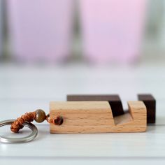 a wooden keychain with beads on it sitting next to a pair of metal rings