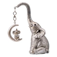 an elephant figurine sitting next to a keychain with a mouse on it