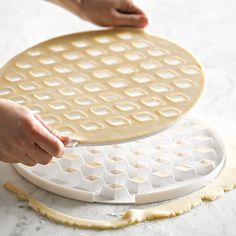 two waffles being made on top of each other with one person's hand