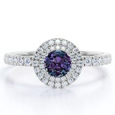 Make every day a cloud nine day with this Double Halo - 1.75 Carat Round Cut Lab Created Alexandrite and Moissanite - Pave Shank Engagement Ring - 18K White Gold Plating over Silver. Professionally handcrafted into a fine round cut by our skilled jewelers, this alluring alexandrite band features 0.5 carat alexandrite and 0.75 carat side-stone moissanites on solid white gold plating over silver. Distinctive and extraordinary, this alexandrite engagement ring is perfect for those who would love to Halo 1, Shank Engagement Ring, Alexandrite Engagement Ring, Alexandrite Ring, Cloud Nine, Double Halo, Birthstone Jewelry, 18k Rose Gold, Promise Rings