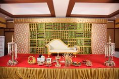 a red table topped with lots of gold and silver items on top of a red cloth covered table