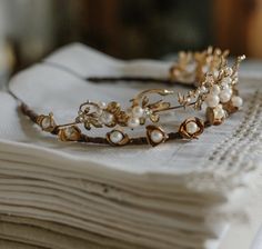 a tiara sitting on top of a stack of napkins next to a white cloth