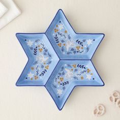 two blue star shaped dishes sitting on top of a table