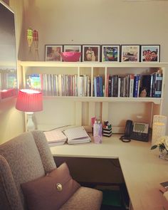 a desk with a chair, lamp and bookshelf