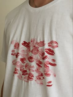 a man wearing a white shirt with red lipstick prints on it