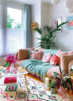 a living room filled with lots of furniture and plants on top of the couches