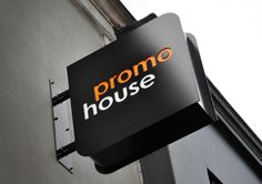 a black sign hanging from the side of a building that says promo house on it