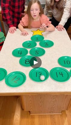 two children and an adult are sitting at a table with numbers on it