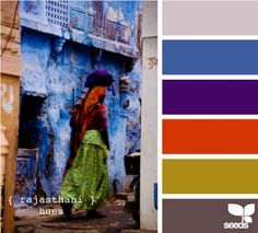 an image of a woman walking down the street in front of a building with blue walls