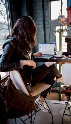 a person sitting at a table with a laptop