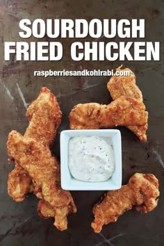 some fried chicken is on a table with ranch dip in the middle and sauce in the middle