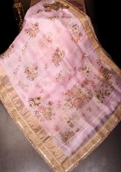 Elevate your elegance with this Pure Organza Silk Saree in a trendy dusty pink hue, adorned with a vibrant floral digital print that adds a refreshing touch to your wardrobe. The lightweight organza fabric drapes beautifully, providing a soft and airy feel, perfect for any festive occasion or casual gathering. Featuring a delicate lace trim border, this saree seamlessly blends modern aesthetics with classic charm, enhancing its overall appeal. Ideal for weddings, parties, or daytime events, this Pink Embroidered Raw Silk Saree, Pink Sheer Slub Silk Dupatta, Pink Resham Embroidered Tissue Silk Fabric, Pink Floral Embroidered Raw Silk Fabric, Semi-stitched Pink Silk Embroidered Fabric, Organza Silk Saree, Organza Fabric, Draped Fabric, Dusty Pink